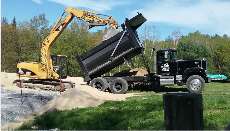 JCL Septic Services truck and excavator at a job site